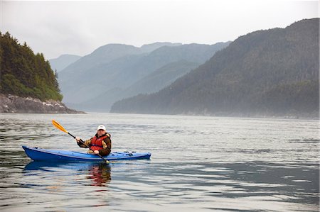 Mature man kayaking with mountains in the background Stock Photo - Premium Royalty-Free, Code: 6128-08799064