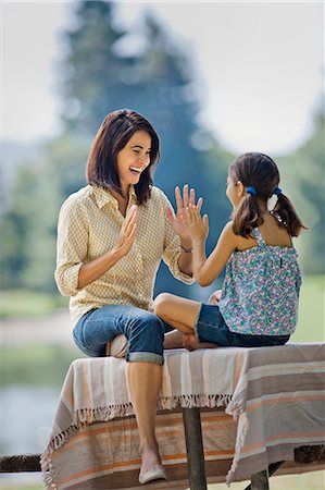 simsearch:6128-08799010,k - Happy mother and daughter playing a hand game in the park. Photographie de stock - Premium Libres de Droits, Code: 6128-08799003