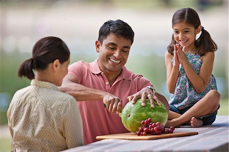 passion fruit - Family enjoying watermelon during a picnic at the park. Photographie de stock - Premium Libres de Droits, Code: 6128-08799010