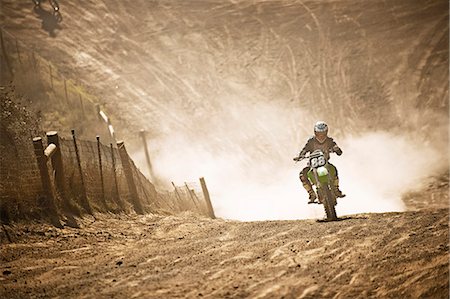 simsearch:6128-08799142,k - Motorbike racer racing through a dirt road. Photographie de stock - Premium Libres de Droits, Code: 6128-08799142
