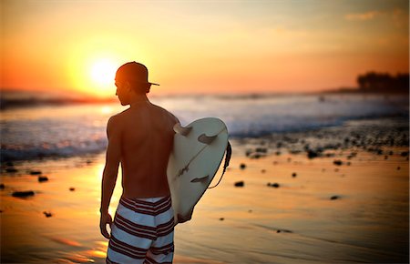 Boy on beach with surfboard, El Salvador. Stock Photo - Premium Royalty-Free, Code: 6128-08799157