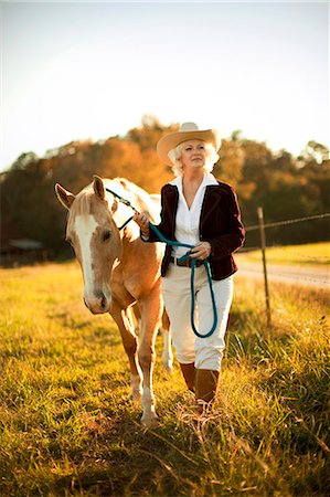 simsearch:6128-08840980,k - Woman walking horse through pasture. Photographie de stock - Premium Libres de Droits, Code: 6128-08799111