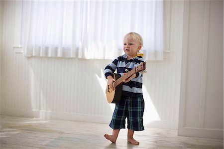 Toddler playing with a wooden banjo. Photographie de stock - Premium Libres de Droits, Code: 6128-08727441