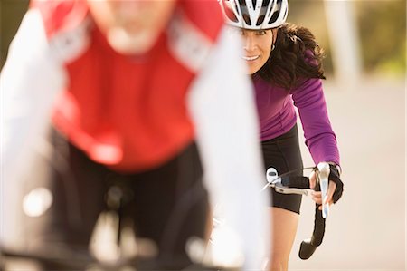 simsearch:6128-08738600,k - Female cyclist seen over the shoulder of a male cyclist Stock Photo - Premium Royalty-Free, Code: 6128-08727453