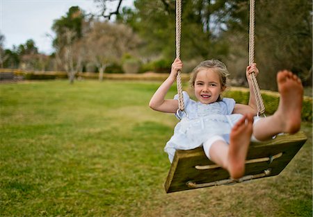 Portrait of a little girl playing on a swing in the back garden. Stockbilder - Premium RF Lizenzfrei, Bildnummer: 6128-08727496