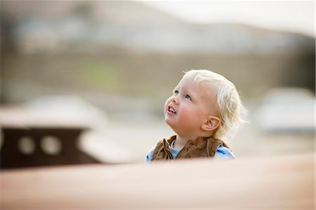 shoulders mom - Young toddler looking upwards while outdoors. Photographie de stock - Premium Libres de Droits, Code: 6128-08727429