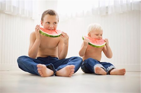 simsearch:649-07905189,k - Two brothers dressed identically and eating watermelon Photographie de stock - Premium Libres de Droits, Code: 6128-08727435