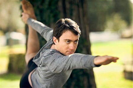 strong depth of field - Focused middle aged man practicing yoga in the park. Stock Photo - Premium Royalty-Free, Code: 6128-08727567