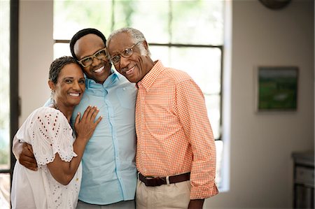 eyeglasses people smiling - Adult son taking picture with his parents. Stock Photo - Premium Royalty-Free, Code: 6128-08727750
