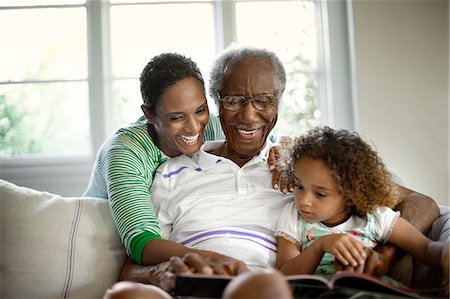 senior pointing - Grandparents reading with young granddaughter. Stock Photo - Premium Royalty-Free, Code: 6128-08727757