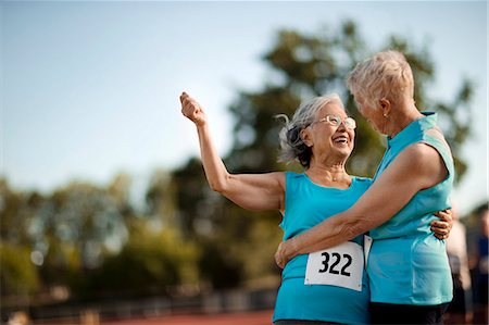 Two happy senior women embracing after competing in an athletic event. Stock Photo - Premium Royalty-Free, Code: 6128-08727851