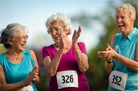 Three smiling senior women clapping and laughing during an athletics competition. Stock Photo - Premium Royalty-Free, Code: 6128-08727857