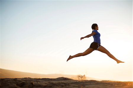 Young woman leaping at the beach. Stock Photo - Premium Royalty-Free, Code: 6128-08727801