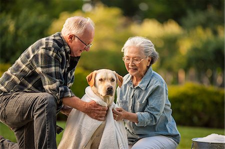 elderly couples - Happy senior couple bathing their dog in their back yard. Stock Photo - Premium Royalty-Free, Code: 6128-08727903