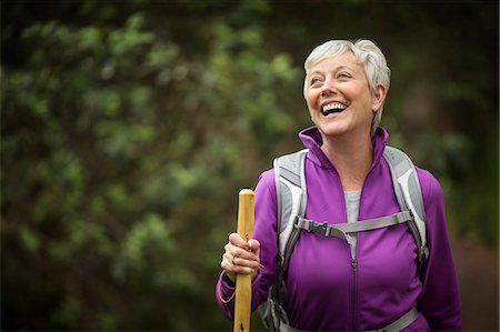 simsearch:6128-08727976,k - Portrait of a mature woman laughing with joy as she enjoys a hike in the forest. Photographie de stock - Premium Libres de Droits, Code: 6128-08728015