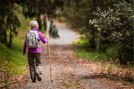 simsearch:6128-08727976,k - Mature woman goes for a hike along a leafy forest trail. Photographie de stock - Premium Libres de Droits, Code: 6128-08728018