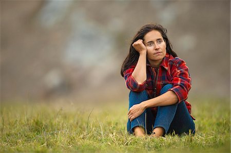 simsearch:6128-08747485,k - Portrait of a thoughtful mid adult woman sitting in a grassy field. Stockbilder - Premium RF Lizenzfrei, Bildnummer: 6128-08728137