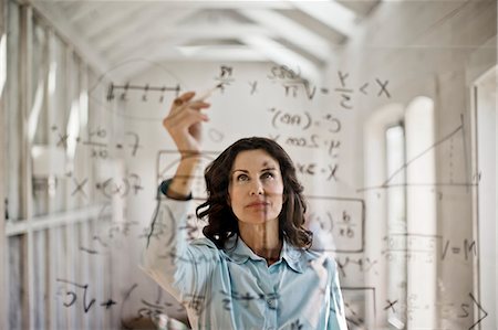 pondering in a classroom - Mathmetician working to solve equation. Stock Photo - Premium Royalty-Free, Code: 6128-08728257