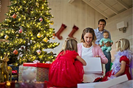 families opening presents at christmas - Family unwrapping Christmas gifts. Stock Photo - Premium Royalty-Free, Code: 6128-08728294