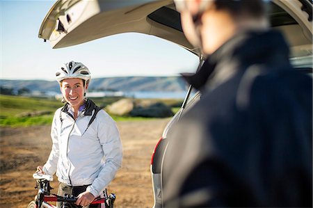 simsearch:6128-08738364,k - Happy couple getting ready to set off on a bike ride. Stock Photo - Premium Royalty-Free, Code: 6128-08728233