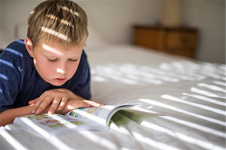 simsearch:6128-08798764,k - Young boy reading in his bedroom. Stock Photo - Premium Royalty-Free, Code: 6128-08728236
