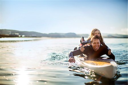 depth of field - Smiling mid adult man paddleboarding with his young daughter. Stock Photo - Premium Royalty-Free, Code: 6128-08728322