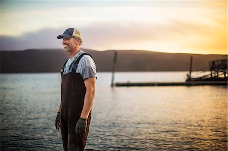 fishing boat man fishing - Mid adult man standing on wharf. Stock Photo - Premium Royalty-Free, Code: 6128-08728425