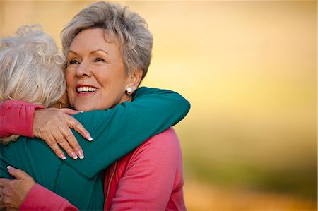 Smiling senior woman hugging her friend. Stock Photo - Premium Royalty-Free, Code: 6128-08737573