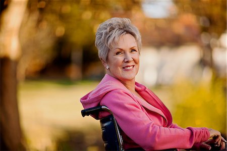 Smiling senior woman sitting in a wheelchair. Stock Photo - Premium Royalty-Free, Code: 6128-08737578