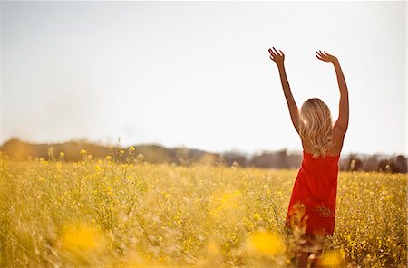 red dress dancing - Portrait of woman in a red dress dancing in a meadow. Stock Photo - Premium Royalty-Free, Code: 6128-08737646