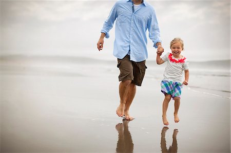 Happy father and young daughter skipping along a beach. Photographie de stock - Premium Libres de Droits, Code: 6128-08737687