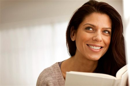 simsearch:693-06018584,k - Smiling mid-adult woman looking inspired while holding a book. Photographie de stock - Premium Libres de Droits, Code: 6128-08737624