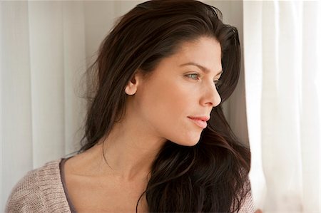 simsearch:6128-08727668,k - Young woman looking out a window. Stock Photo - Premium Royalty-Free, Code: 6128-08737628