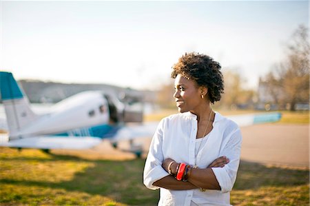 Young woman standing in front of airplane. Stock Photo - Premium Royalty-Free, Code: 6128-08737762