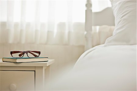 double bedroom - Book and glasses on top of a bedside table next to a bed in a bedroom. Stock Photo - Premium Royalty-Free, Code: 6128-08737784