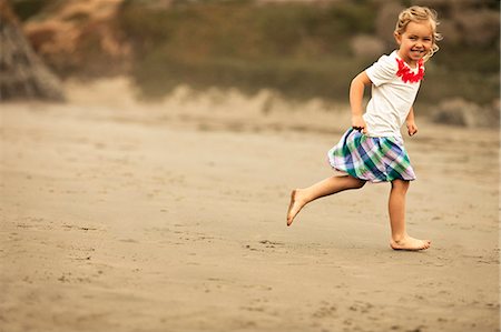 simsearch:6128-08747842,k - Portrait of a smiling young girl skipping on a beach. Stockbilder - Premium RF Lizenzfrei, Bildnummer: 6128-08737705