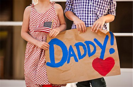 simsearch:614-08726632,k - Young brother and sister holding a sign on their front porch. Fotografie stock - Premium Royalty-Free, Codice: 6128-08737845