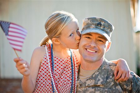 simsearch:6128-08737863,k - Portrait of a smiling soldier being kissed on the cheek by his young daughter. Stock Photo - Premium Royalty-Free, Code: 6128-08737850