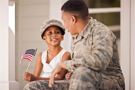 family and army - Smiling young girl sitting with her father on the front steps of their home. Stock Photo - Premium Royalty-Free, Code: 6128-08737856
