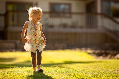 Young girl skipping across a back yard. Stock Photo - Premium Royalty-Free, Code: 6128-08737888