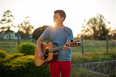 simsearch:6128-08728230,k - Teenage boy playing an acoustic guitar. Fotografie stock - Premium Royalty-Free, Codice: 6128-08737891