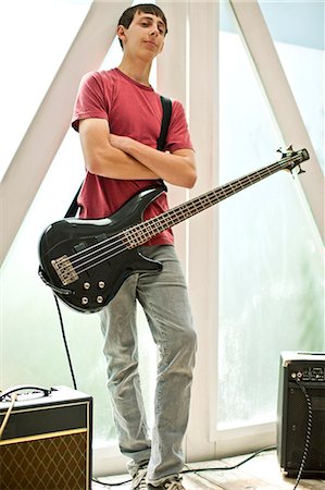 simsearch:6128-08737935,k - Portrait of a teenage boy standing with a bass guitar and his arms crossed. Stock Photo - Premium Royalty-Free, Code: 6128-08737922