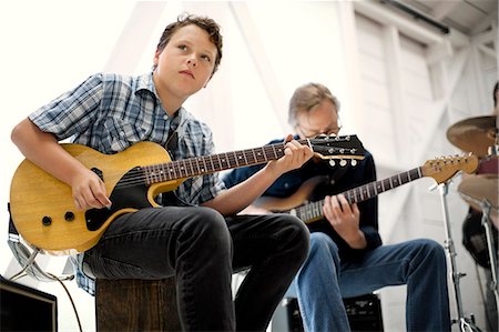 Mid adult man and teenage boy playing guitar together. Foto de stock - Sin royalties Premium, Código: 6128-08737931