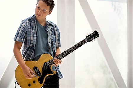Teenage boy playing an electric guitar. Stock Photo - Premium Royalty-Free, Code: 6128-08737934