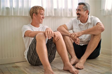 simsearch:6128-08737935,k - Mature adult man sitting on the floor with his teenage son. Stock Photo - Premium Royalty-Free, Code: 6128-08738085