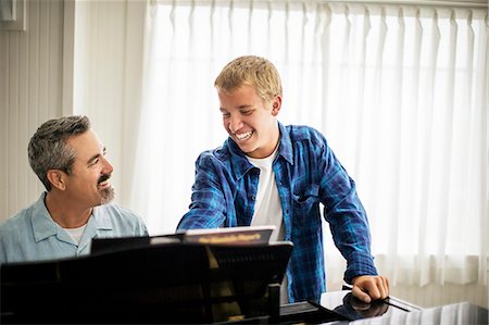 simsearch:6128-08737935,k - Smiling father playing piano with his teenage son. Stock Photo - Premium Royalty-Free, Code: 6128-08738089