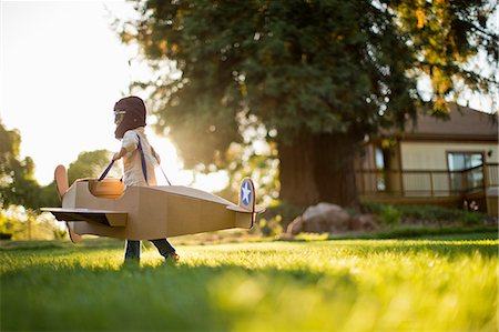 simsearch:400-04658762,k - Young boy having fun pretending to be a pilot in a cardboard plane. Stockbilder - Premium RF Lizenzfrei, Bildnummer: 6128-08738010