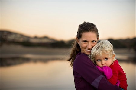shoulders mom - Portrait of a young woman holding her toddler daughter on a beach. Photographie de stock - Premium Libres de Droits, Code: 6128-08738142