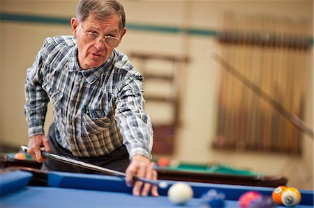 Senior man playing a game of pool. Stock Photo - Premium Royalty-Free, Code: 6128-08738146