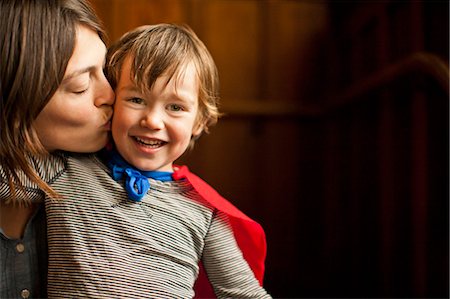Happy mother kissing her smiling young son on the cheek. Stock Photo - Premium Royalty-Free, Code: 6128-08738120